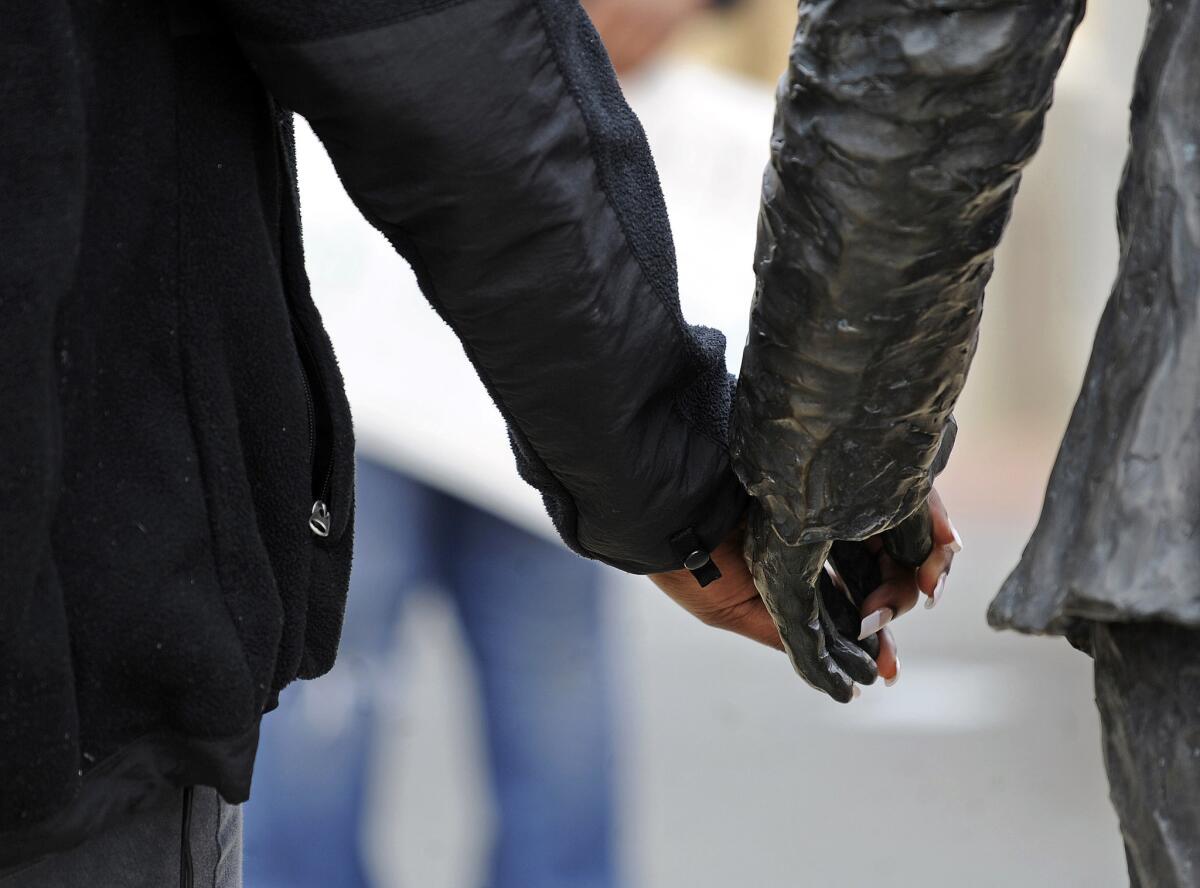 Students hold hands with the James Meredith statue during a gathering at the University of Mississippi after a noose was found around the statue's neck.