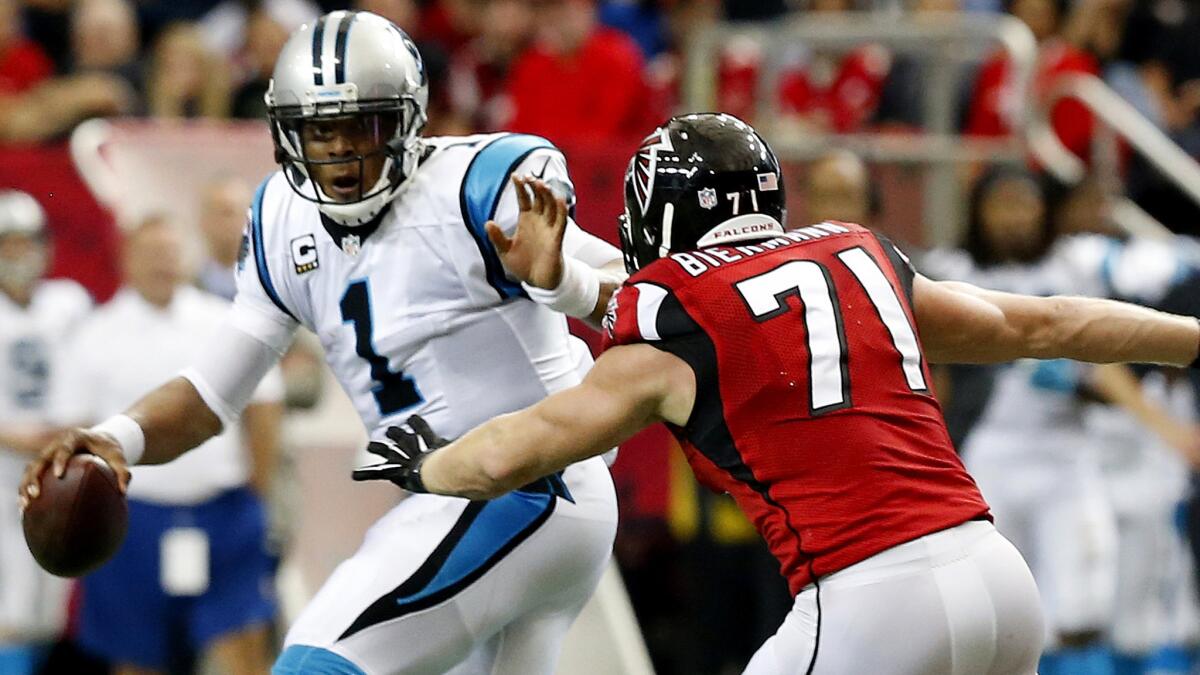 Panthers quarterback Cam Newton tries to scramble from the pressure of Falcons linebacker Kroy Biermann (71) during the first half Sunday.