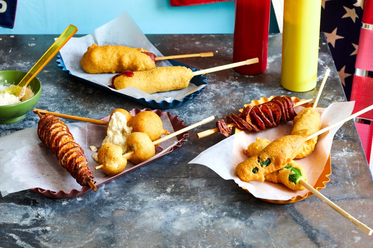 Several baskets hold food that's been battered and fried on a stick. Squeeze bottles of ketchup and mustard sit nearby.