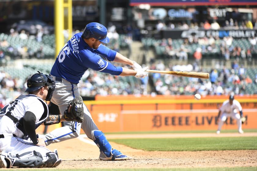 Kansas City Royals pinch hitter Hunter Renfroe, front right, hits an infield single against the Detroit Tigers in the ninth inning of a baseball game, Friday, April. 26, 2024, in Detroit. (AP Photo/Jose Juarez)