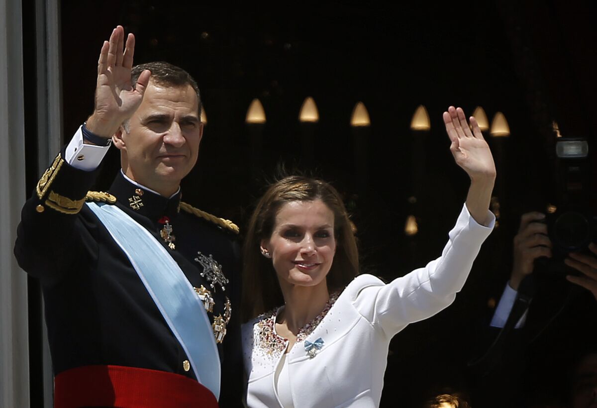 ARCHIVO - Los reyes de España, Felipe VI y Letizia, saludan a la gente desde un balcón del Palacio Real en Madrid