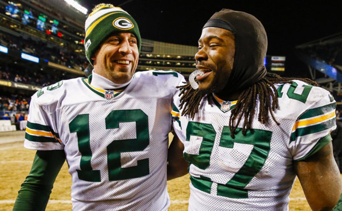 Green Bay teammates Aaron Rodgers, left, and Eddie Lacy smile as they walk off the field following the Packers' win over the Chicago Bears on Sunday. The Packers open the playoffs Sunday against the San Francisco 49ers.