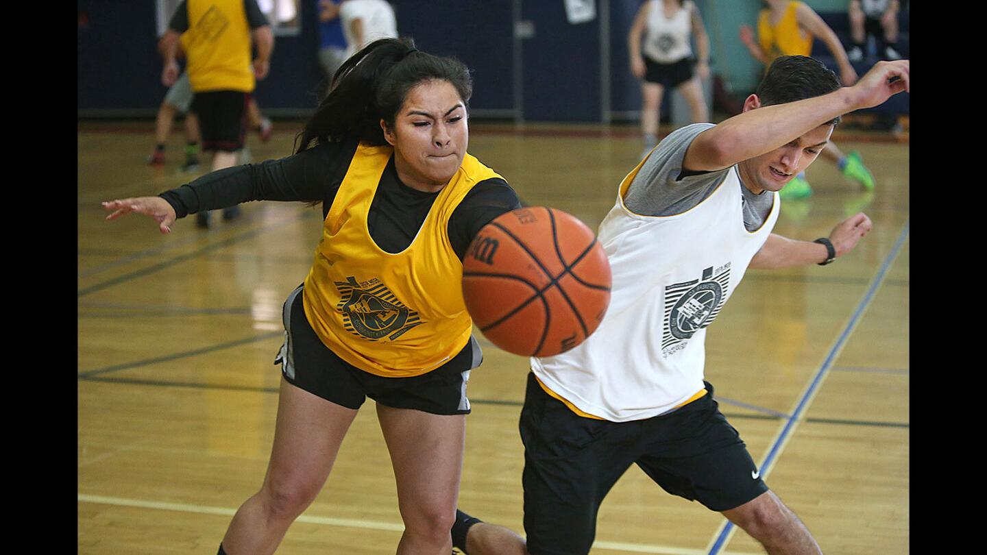 Erika Soto, who helps with the event, steals the ball from an opponent during the 14th annual C3 Basketball Tournament and Community Fair at Costa Mesa’s Downtown Recreation Center on Saturday. The police, churches and other community members organize the fair and three-on-three basketball tournament each year to help connect residents and local agencies.