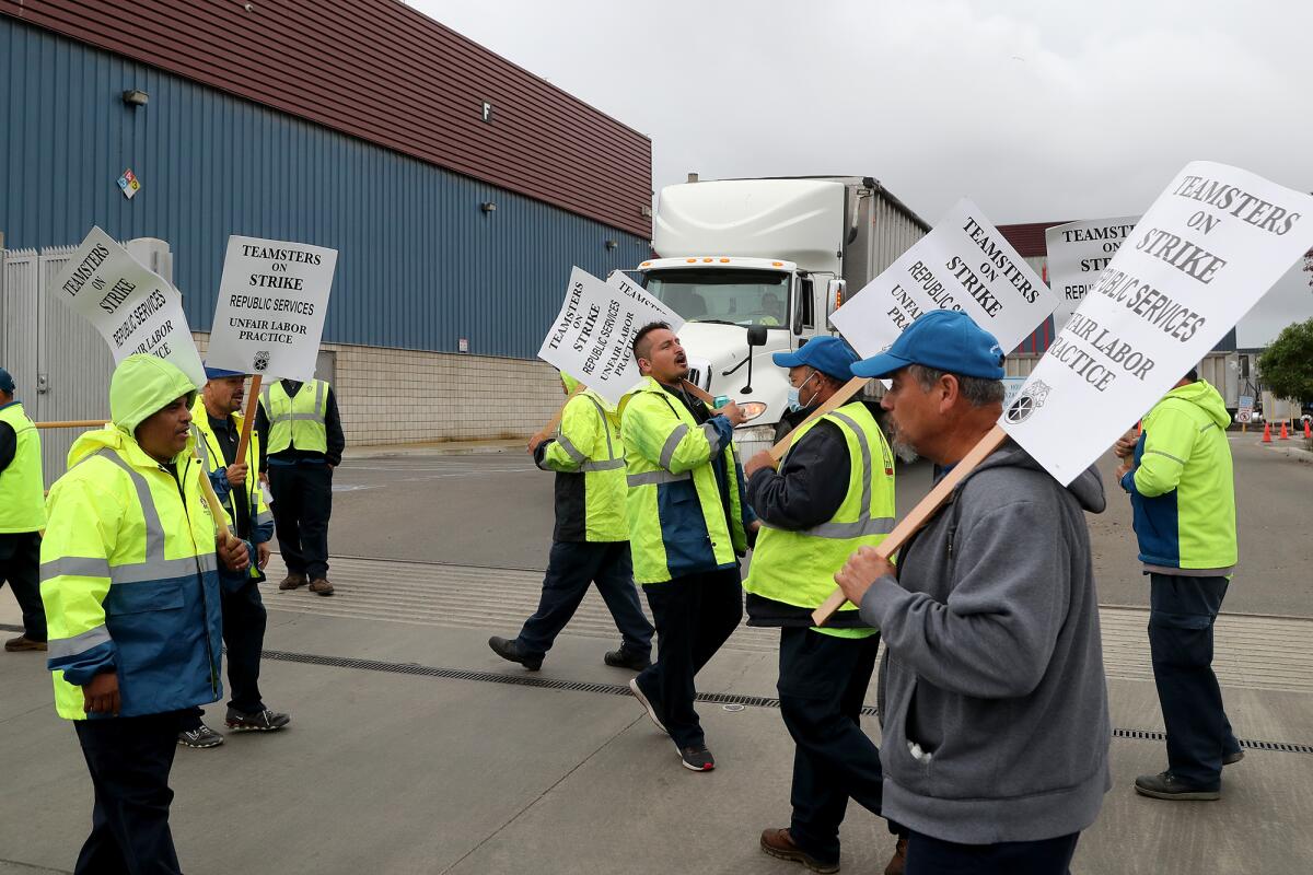 Workers picket outside a Huntington Beach Republic Services facility Dec. 9, the first day of an eight-day strike.