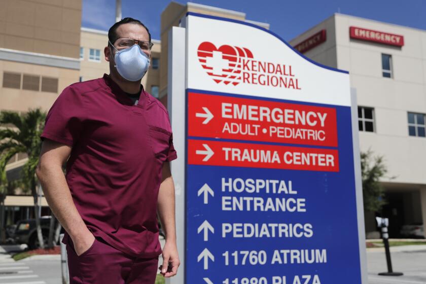 Rublas Ruiz poses for a photograph outside of Kendall Regional Medical Hospital where he works as a nurse in the hospital's intensive care unit, Tuesday, Aug. 11, 2020, in Miami. While other nurses rotate in and out of the COVID-19 ICU unit to limit their exposure to the deadly virus, Ruiz has asked to stay permanently. (AP Photo/Lynne Sladky)