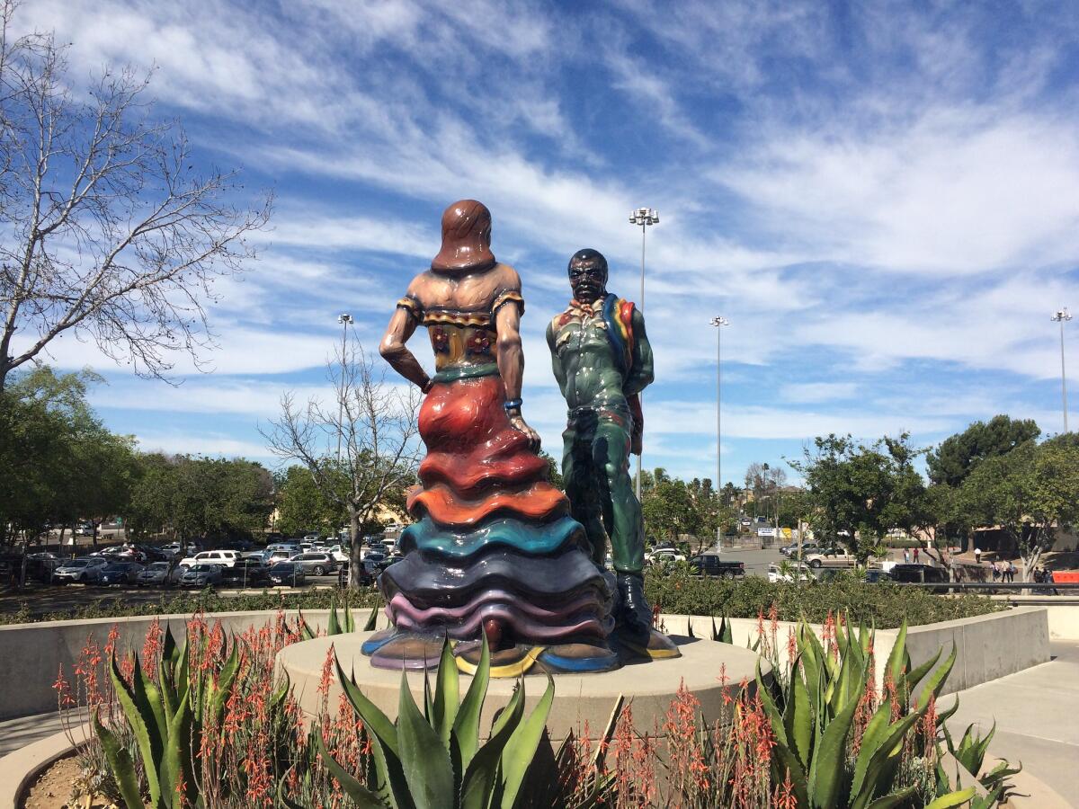A large-scale sculpture of a pair performing Mexican folkloric dance in a public plaza