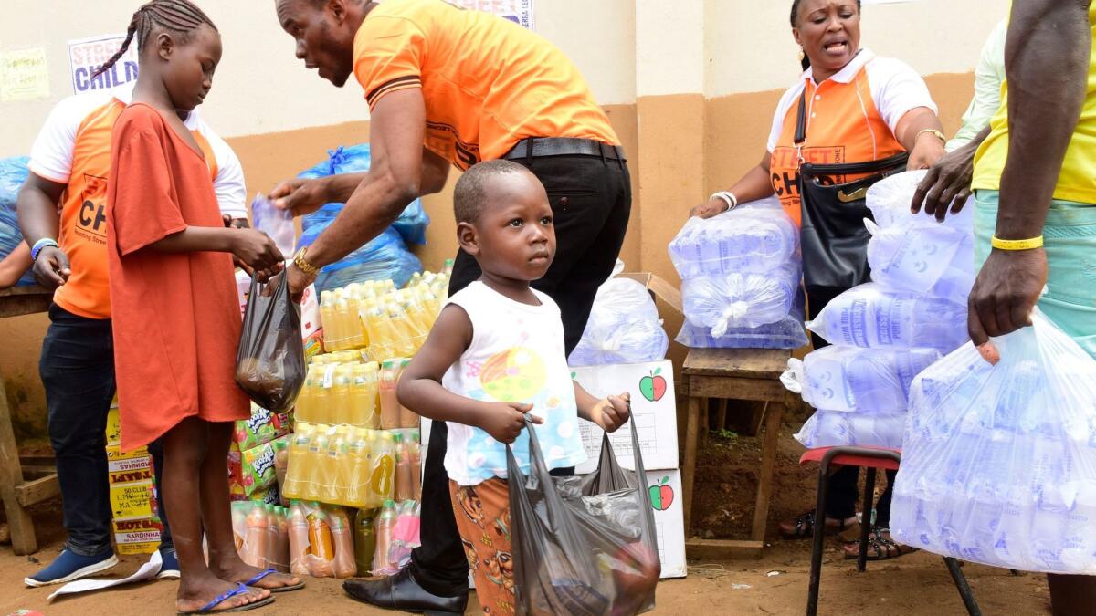 A child receives a bag of supplies from disaster relief volunteers in Freetown, Sierra Leone.