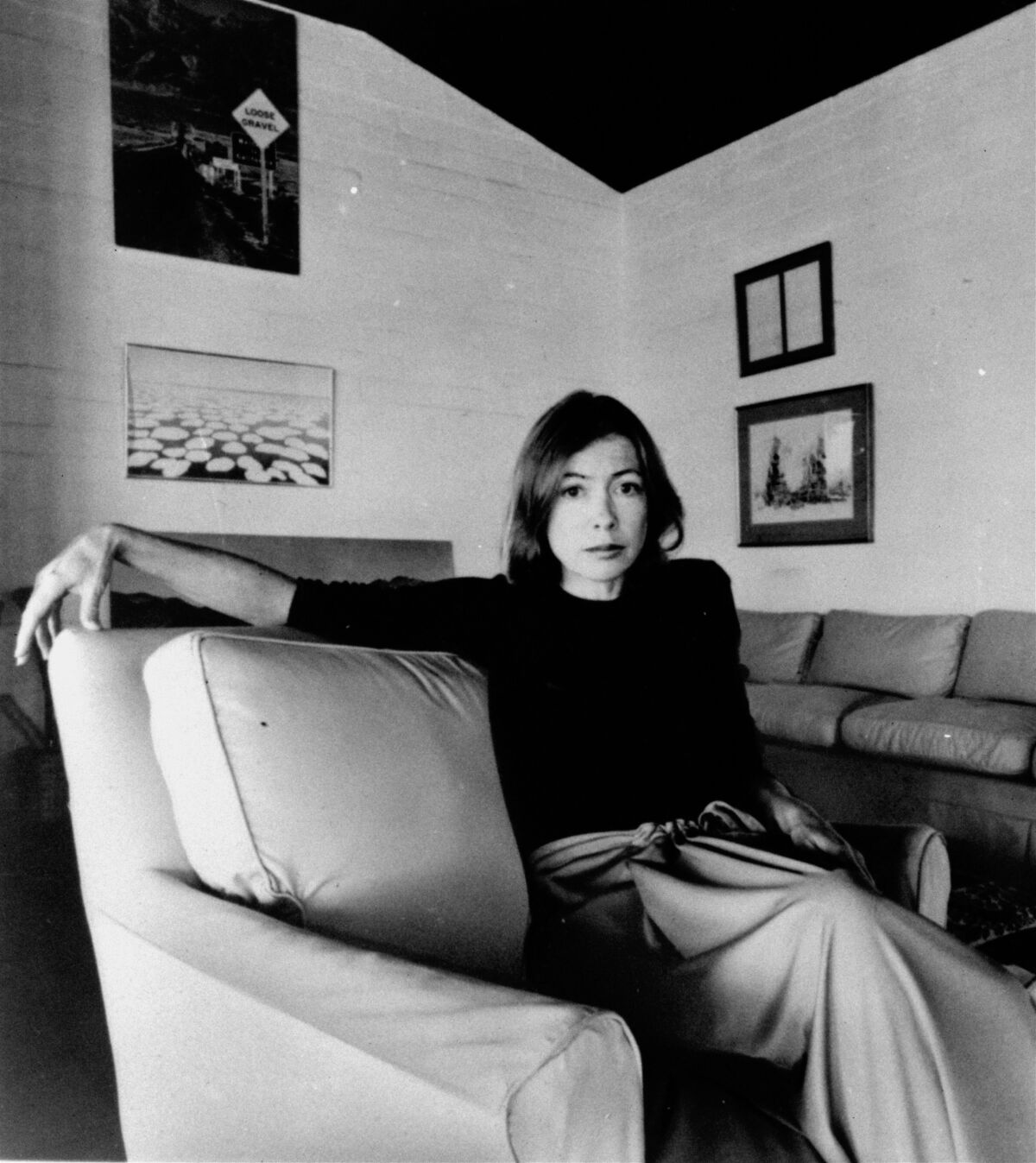 Joan Didion sits on a sofa in this black-and-white photo taken on May 1, 1977.