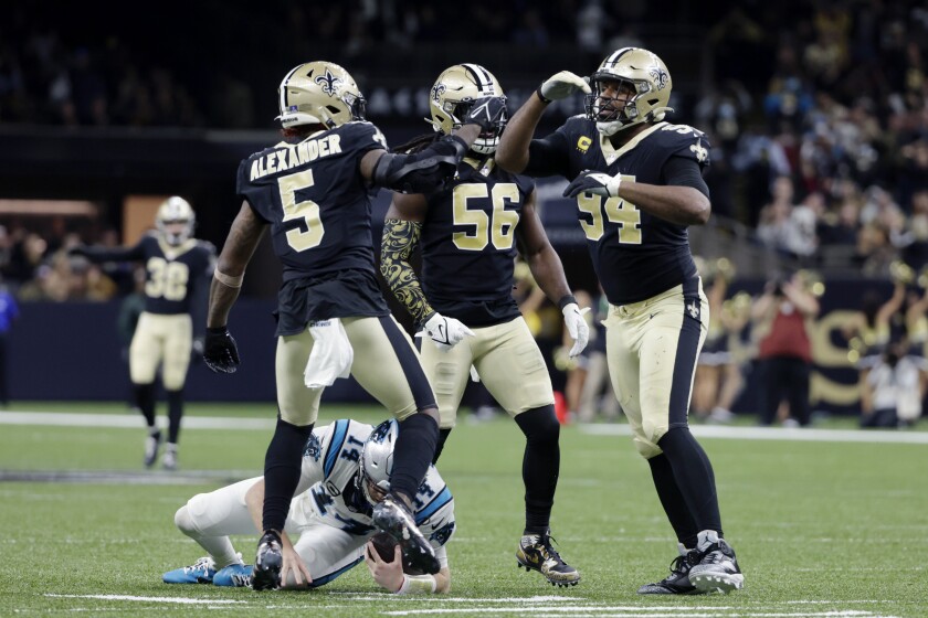 New Orleans Saints defensive end Cameron Jordan (94) celebrates with outside linebacker Demario Davis (56) and middle linebacker Kwon Alexander (5) after sacking Carolina Panthers quarterback Sam Darnold (14) in the second half of an NFL football game in New Orleans, Sunday, Jan. 2, 2022. The Saints won 18-20. (AP Photo/Derick Hingle)