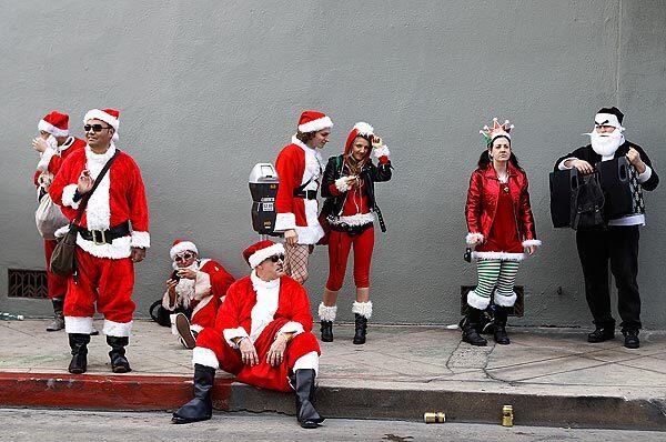 SantaCon revelers wait for others outside Boarders Bar in Hollywood, one of many stops for the day. (Robert Gauthier/Los Angeles Times)