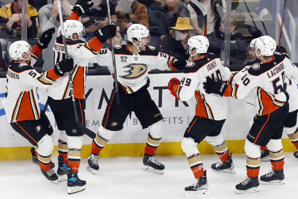 Ducks forward Mason McTavish, center, celebrates with teammates after scoring in overtime against the Boston Bruins.