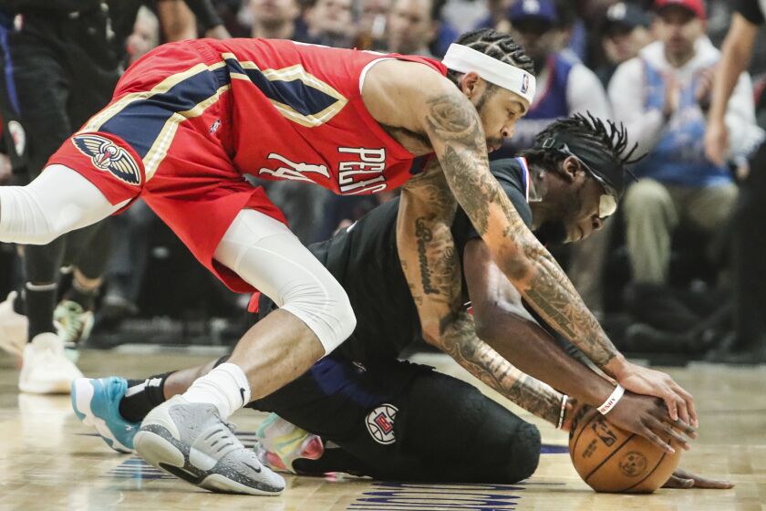 Los Angeles, CA, Friday, April 15, 2022 - New Orleans Pelicans forward Brandon Ingram (14) battles LA Clippers guard Reggie Jackson (1) for a loose ball in the first half of the NBA Play-In tournament at Crypto.com Arena. (Robert Gauthier/Los Angeles Times)