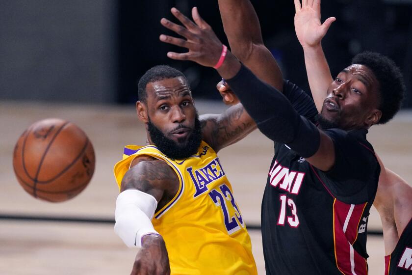 The Lakers' LeBron James passes the ball while pressured by the Heat's Bam Adebayo during Wednesday's game.