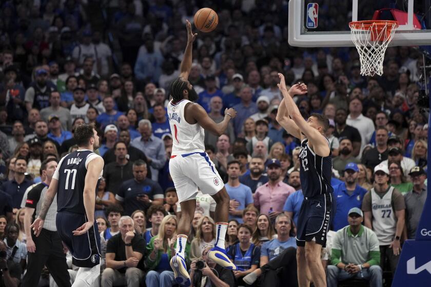 Los Angeles Clippers guard James Harden (1) lofts a shot over Dallas Mavericks forward Maxi Kleber as Mavericks' guard Luka Doncic (77) looks on during the second half of Game 4 of an NBA basketball first-round playoff series, Sunday, April 28, 2024, in Dallas. (AP Photo/Jeffrey McWhorter)