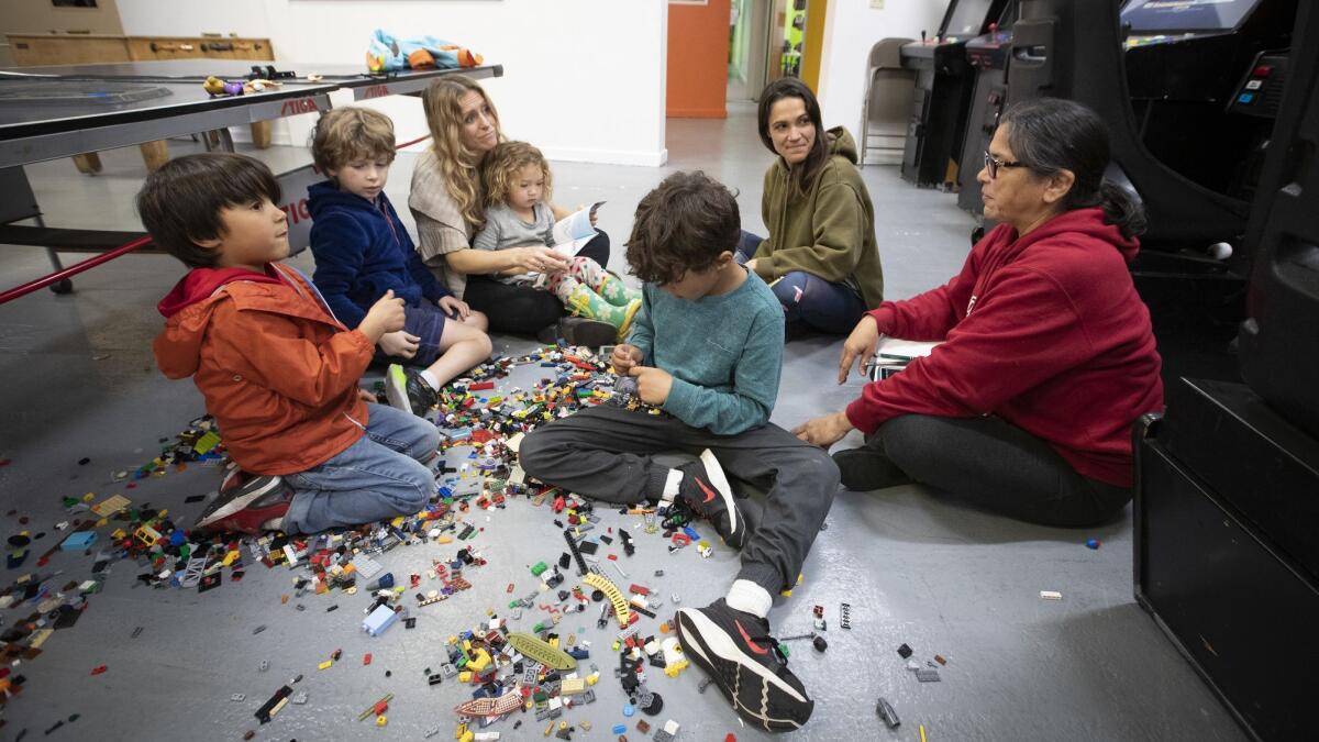 Elysian Heights Elementary parents Jennifer Kunzler, center left, LeTania Kirkland Smith, second from right, and Irene Pena, grandmother and parent volunteer, play with kids on Wednesday at El Centro Del Pueblo in Echo Park while their teachers are out on strike.