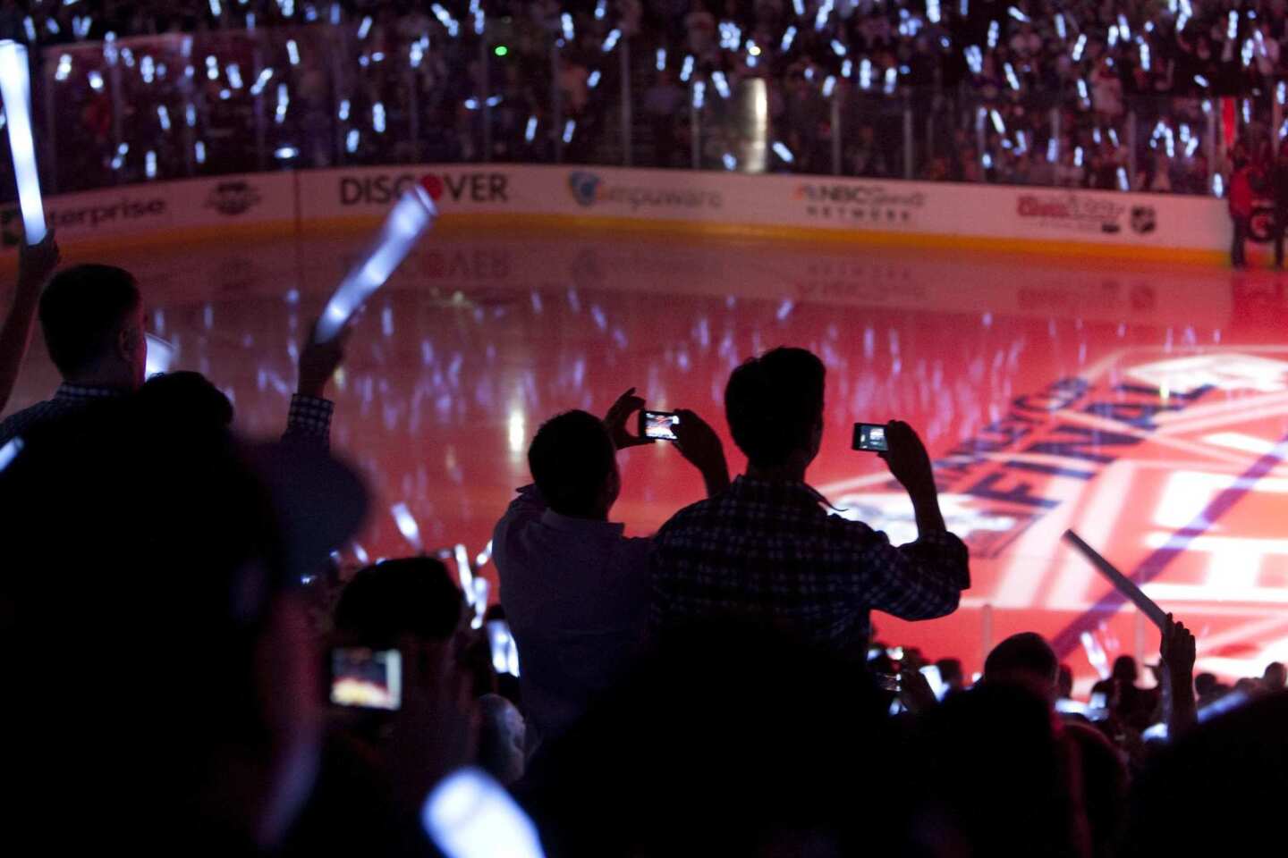 Fans wave glow sticks and snap photographs before the start of Game 3 of the Stanley Cup Final between the Kings and New Jersey Devils at Staples Center on Monday.