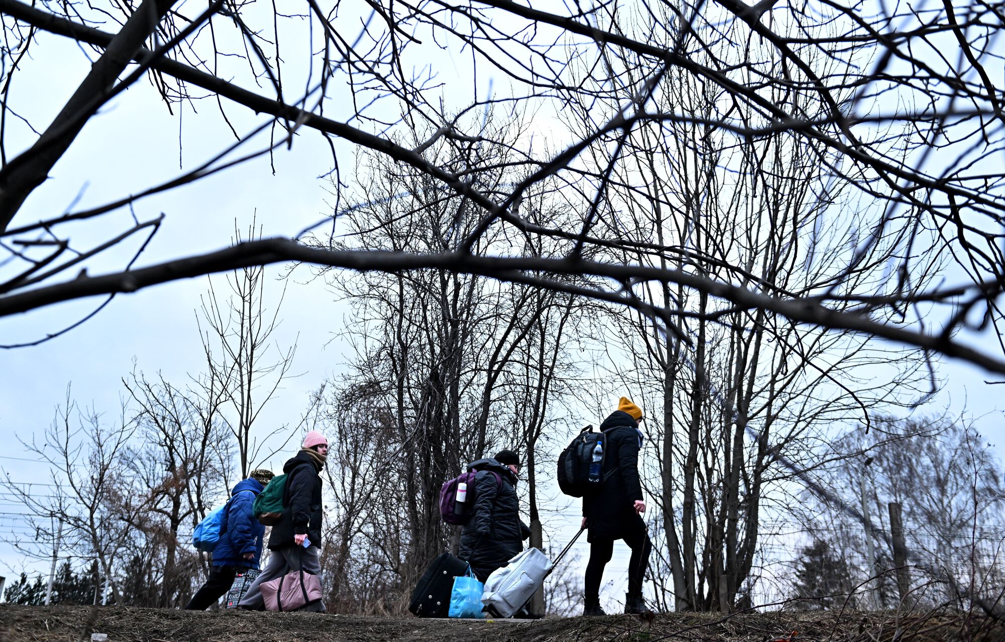 Ukrainian refugees hike to a train station after crossing the border in Medyka, Poland.