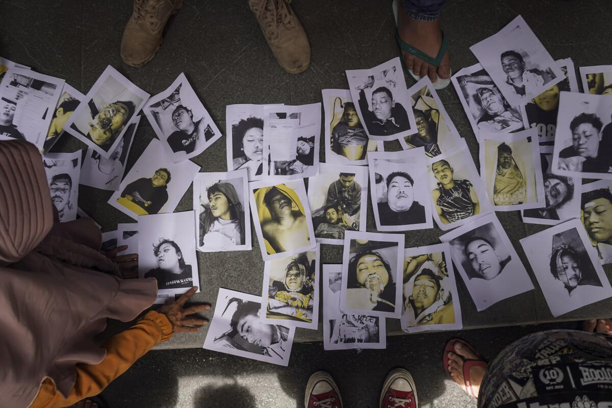Gente que busca por sus familiares observa fotos de las víctimas de la estampida 