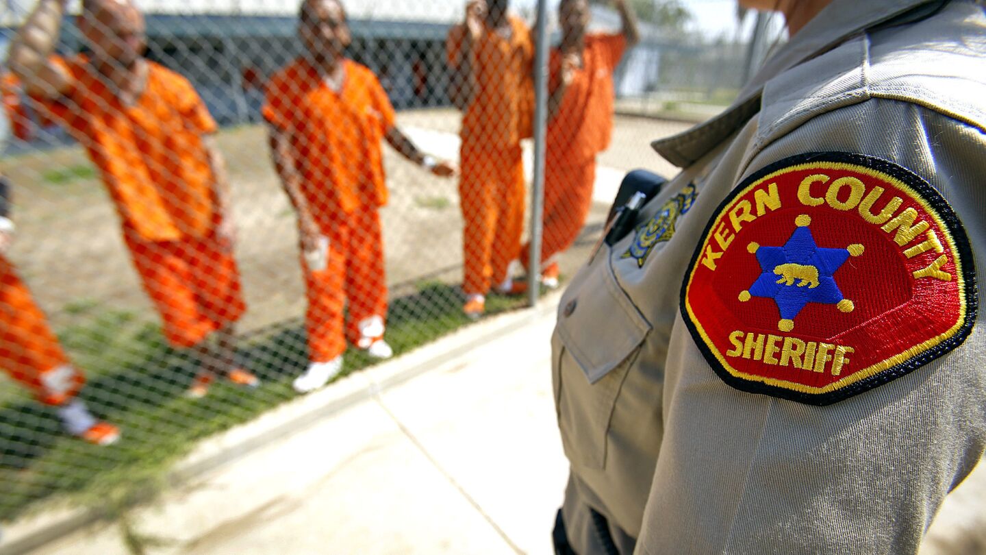 Detention Deputy Tanja Young, right, talks with inmates answering questions about early release in the yard at the Kern County Sheriff's Department's Lerdo Detention Facility in Bakersfield.