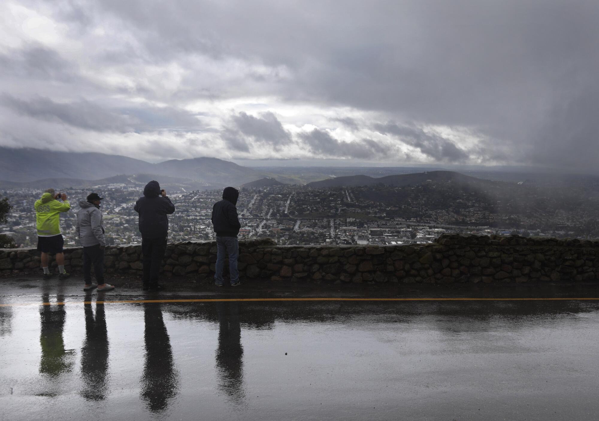 People watch from Mt. Helix Park after the National Weather Service issued a tornado warning.