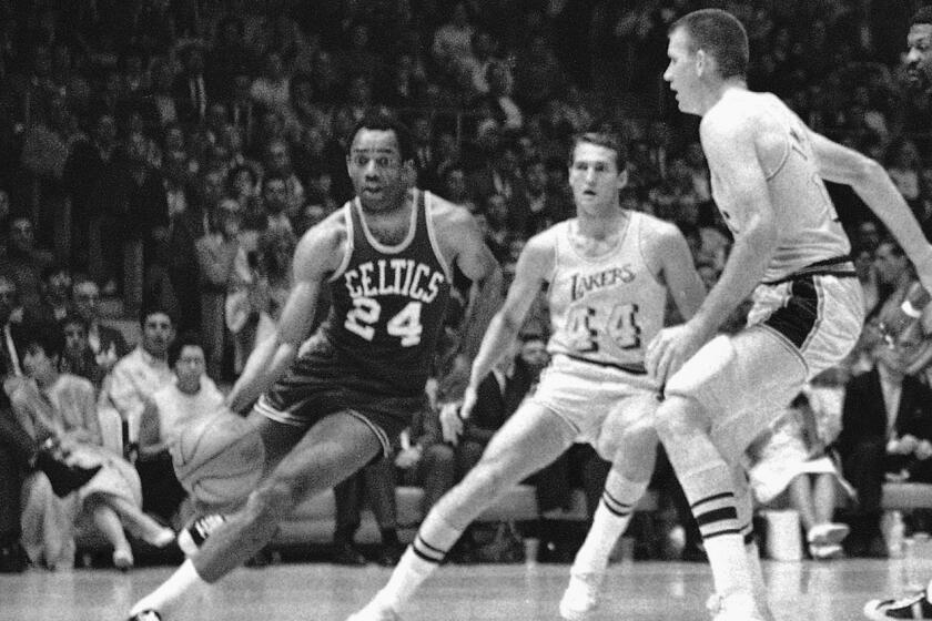 FILE - Boston's Sam Jones, left, drives past the Lakers' Jerry West (44) and drives along the baseline towards the basket.