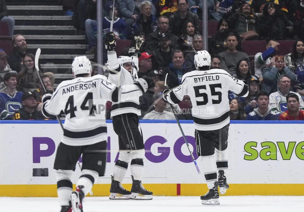 Los Angeles Kings' Anze Kopitar, center, Quinton Byfield (55) and Mikey Anderson (44) celebrate Kopitar's goal