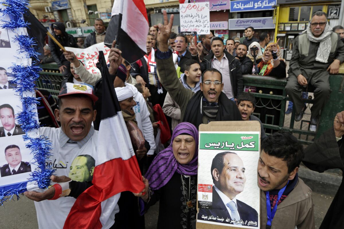Supporters of Egyptian President Abdel Fattah Sisi wave posters with his image in Cairo's Tahrir Square on Monday.
