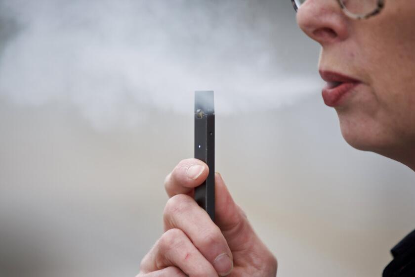 Fotografía de archivo del 16 de abril de 2019 de una mujer exhalando vapor de un cigarrillo electrónico Juul en Vancouver, Washington.