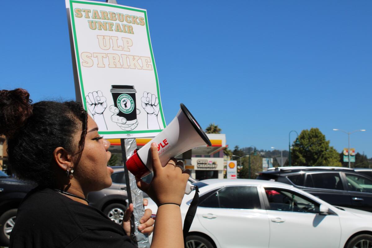 A Starbucks worker in Santa Cruz is chanting into a megaphone 