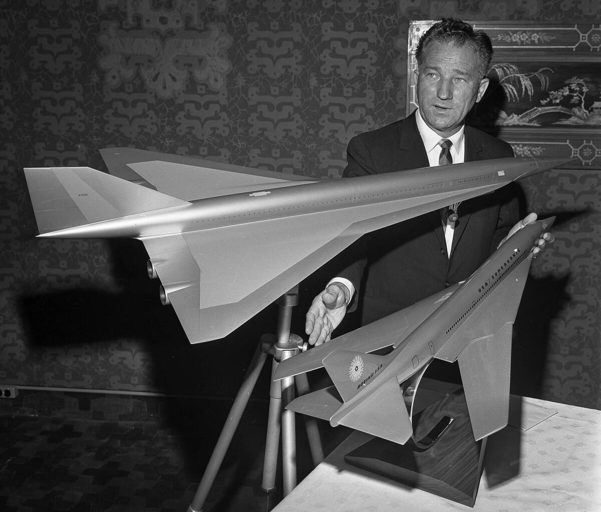 July 13, 1964: Federal Aviation Agency test pilot Joe Tymczyszyn displays models of Lockheed, top, and Boeing, bottom, supersonic transport planes.