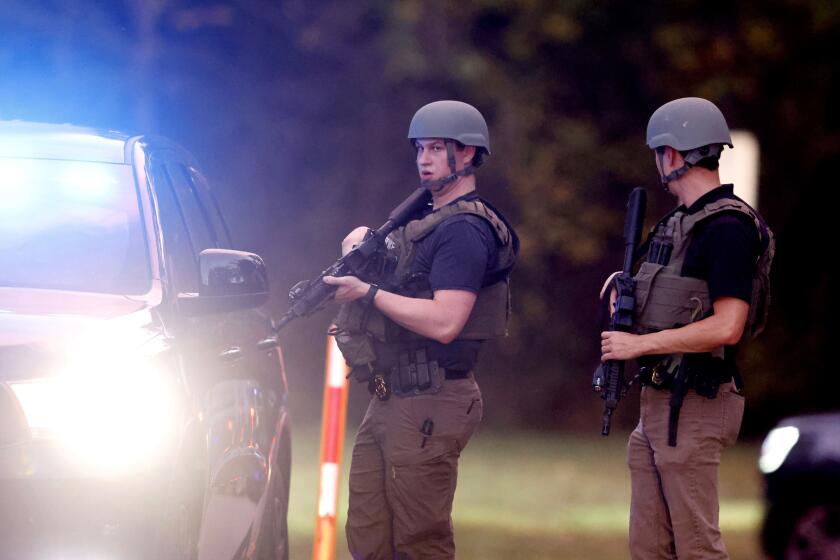Law enforcement stand at the entrance to Neuse River Greenway Trail parking at Abington Lane following a shooting in Raleigh, N.C., Thursday, Oct. 13, 2022. (Ethan Hyman/The News & Observer via AP)