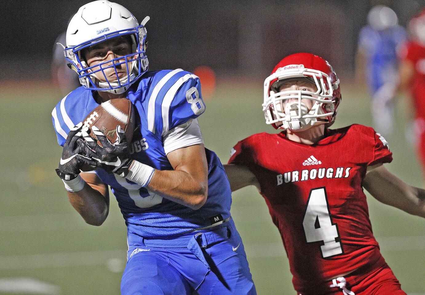 Burbank's Erik Harutyunyan makes a big catch as the ball drops in over his shoulder against Burroughs' Nathan Turner in a big-game rival Pacific League football game at Memorial Field in Burbank on Friday, October 26, 2018.