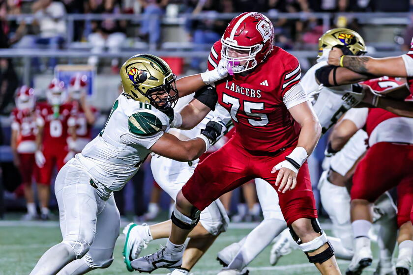 Offensive tackle Lucas Rhoa of Orange Lutheran isn't bothered by a defender sticking his hand near his face.