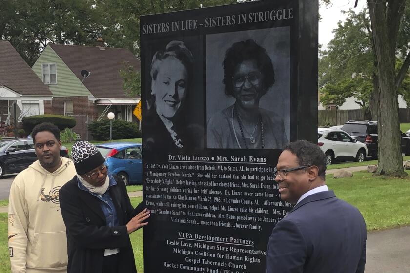 From left, relatives of Sarah Evans and Detroit Deputy Mayor Todd Bettison view 7-foot-tall granite monument commemorating Evans and her friend, Viola Liuzzo on Thursday, Sept. 28, 2023 at Viola Liuzzo Park in northwest Detroit. Liuzzo was a white mother who was slain in Alabama while shuttling demonstrators after the 1965 Selma-to-Montgomery voting rights march. (AP Photo/Corey Williams)