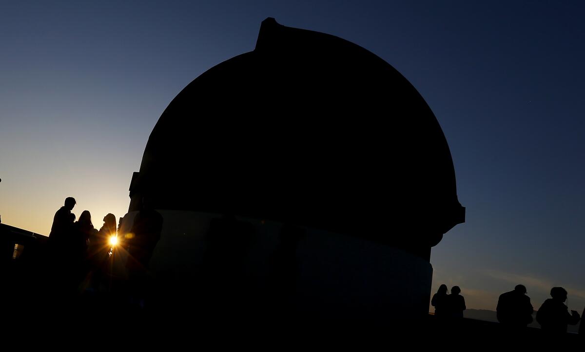 Visitors take in the sunset from the roof of the Griffith Observatory