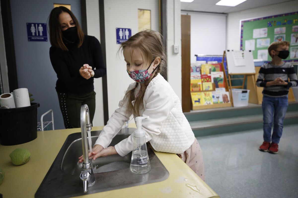 Teacher assistant Susan Silic oversees proper hand washing at Lupin Hill Elementary School.