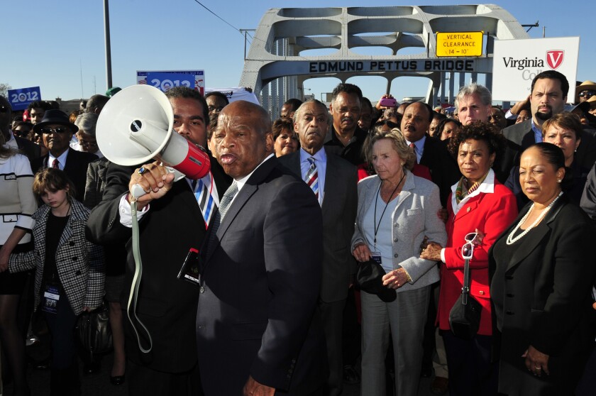 John Lewis speaks with a bullhorn to a crowd gathered on the historic Edmund Pettus Bridge in Selma, Alabama, in 2012.