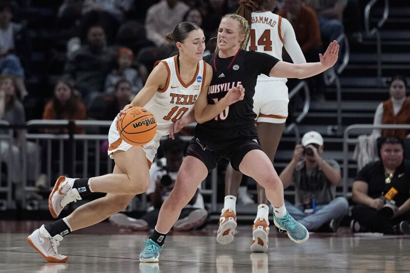 Texas guard Shay Holle, left, drives around Louisville guard Hailey Van Lith, right, during the first half of a second-round college basketball game in the NCAA Tournament in Austin, Texas, Monday, March 20, 2023. (AP Photo/Eric Gay)