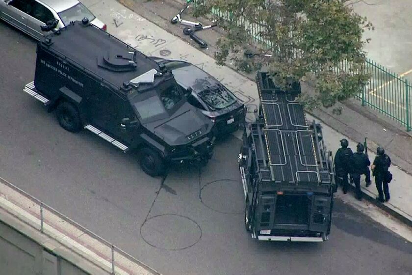 LOS ANGELES CA JULY 30, 2019 -- LAPD SWAT officers approach a Toyota Prius authorities believe was used in the possible kidnapping of a woman in Monrovia was located this morning in downtown Los Angeles with the suspect barricaded inside the car Tuesday morning, July 30, 2019. (KTLA)