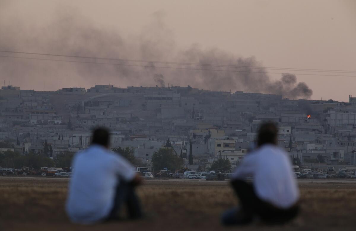 Turkish Kurds watch from the border as smoke rises from the Syrian city of Kobani during fighting between Islamic State militants and Kurdish fighters on Oct. 7.