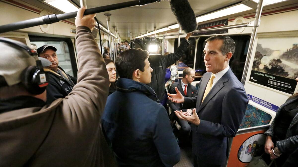 Mayor Eric Garcetti talks to reporters while riding the Metro Red Line on Dec. 6, 2016. The construction of rail lines across the city, he says, is one of many signs of robust urban renewal.