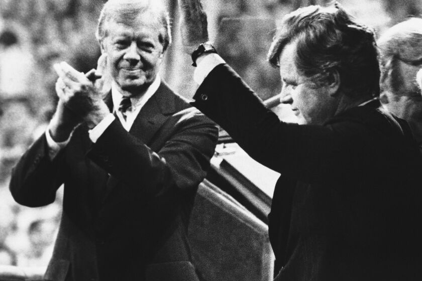 FILE - U.S. President Jimmy Carter, left, applauds as Sen. Edward Kennedy waves to cheering delegates at the Democratic National Convention in New York's Madison Square Garden, Aug. 14, 1980. As Carter receives home hospice care at the age of 98, misconceptions about his life are coming into focus. Most are rooted in some truth but need more context. (AP Photo, File)