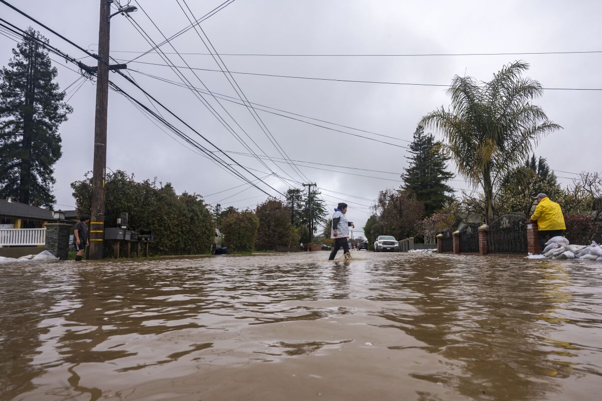 A woman walks through floodwaters in Watsonville on Friday.