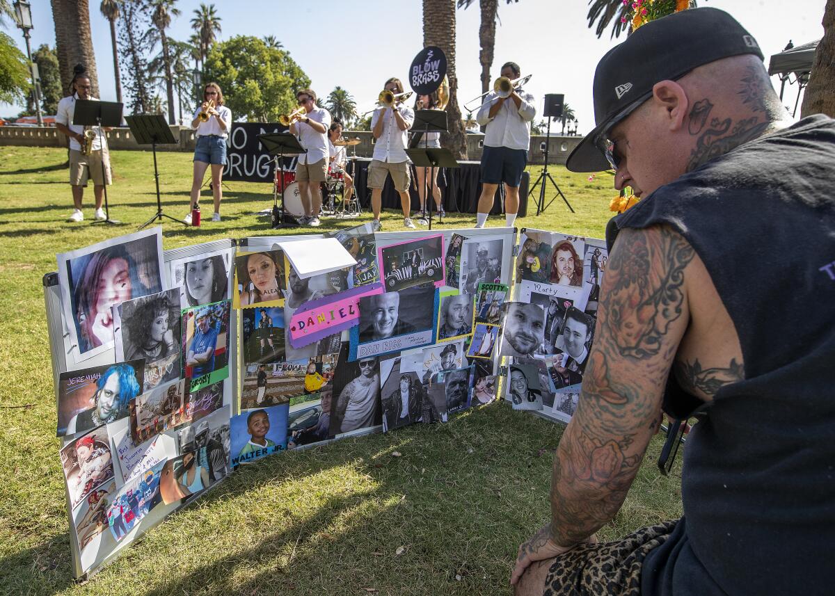 LOS ANGELES, CA-AUGUST 31, 2023:Kent Avery of Los Angeles looks at photographs of people who all died from drug overdoses, during an event at MacArthur Park on International Overdose Awareness Day. Avery said that 3 of his friends who died from drug overdoses were pictured in the display. (Mel Melcon / Los Angeles Times)