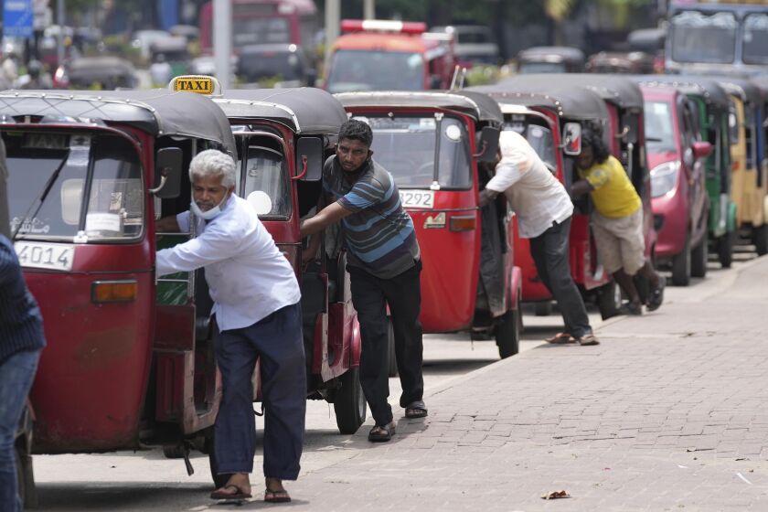 FILE- Sri Lankan auto rickshaw drivers queue up to buy petrol near a fuel station in Colombo, Sri Lanka, April 13, 2022. A U.S. petroleum company signed an agreement with Sri Lanka on Thursday allowing it to import and sell fuel in the country, less than a month after Chinese petroleum giant Sinopec also acquired rights to enter the retail market, as the Indian Ocean nation grapples with an economic and energy crisis. (AP Photo/Eranga Jayawardena, File)
