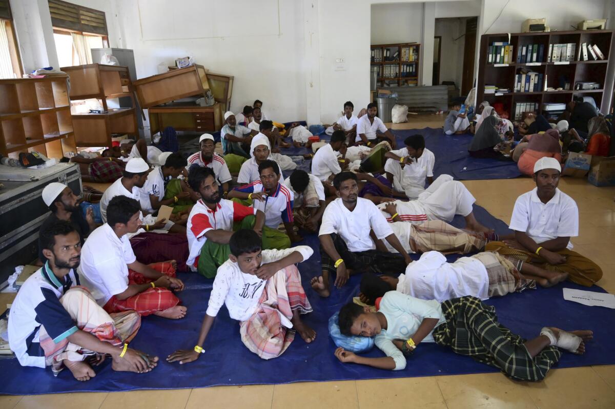 Rohingya refugees rescued from a capsized boat rest at a temporary shelter.