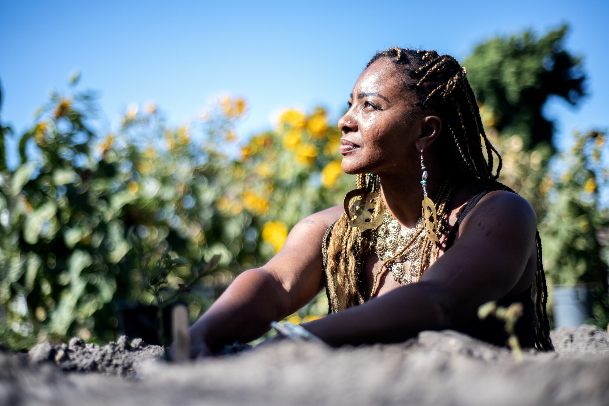 Genea Richardson sits in the sun in a garden.