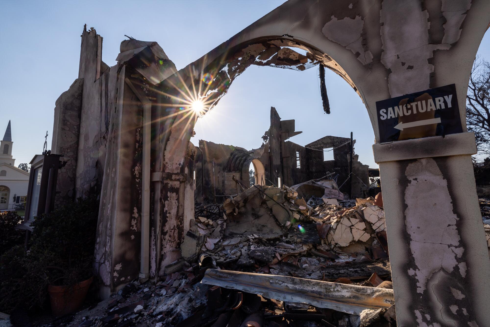 The sun shines through church wreckage.