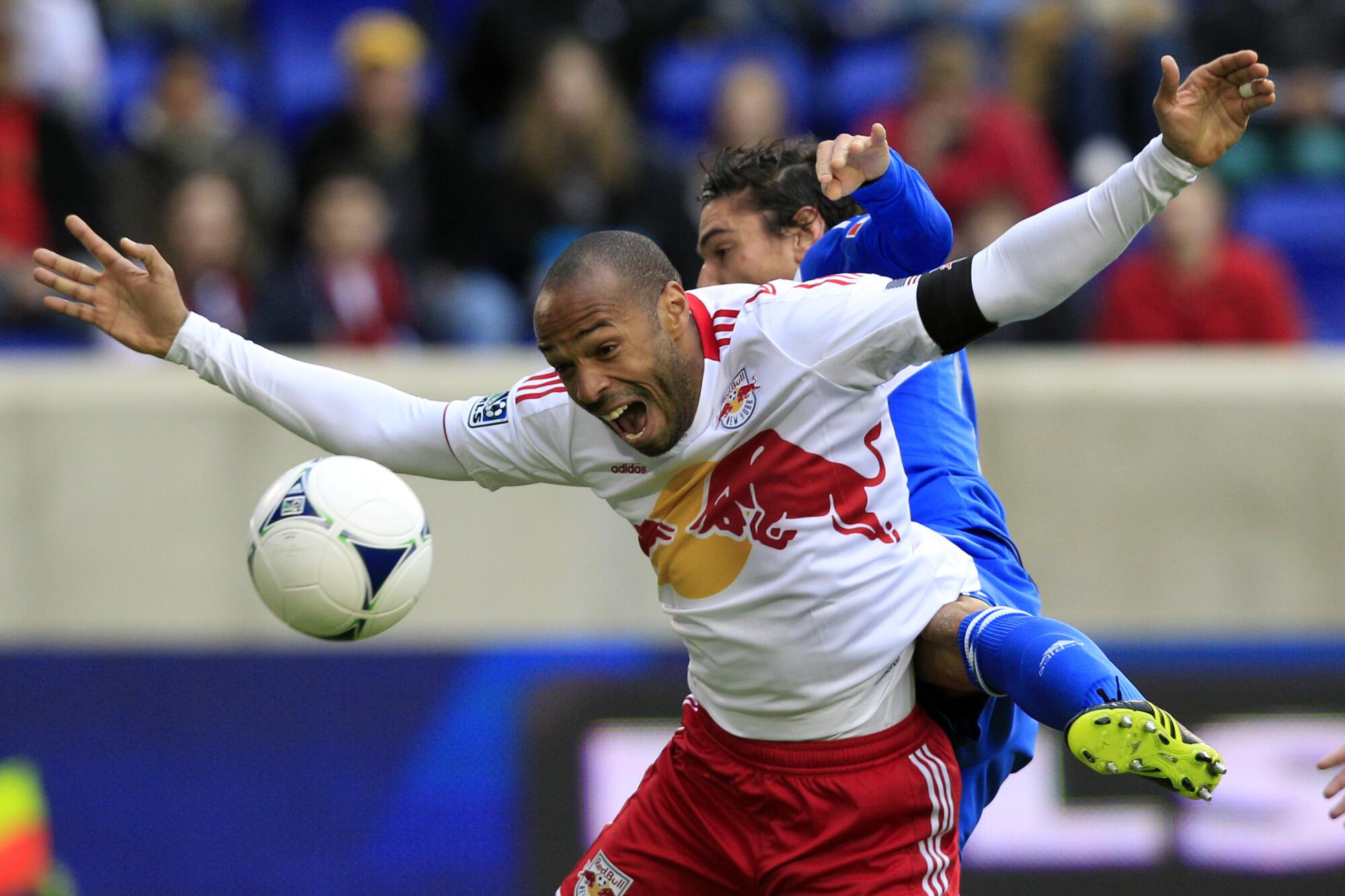 New York Red Bulls forward Thierry Henry, front, reacts as he is hit from behind by Montreal Impact's Zarek Valentin