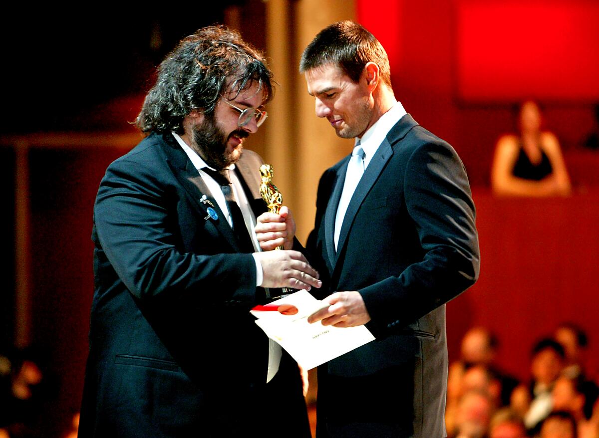 Director Peter Jackson accepts the directing Oscar from Tom Cruise in 2004.